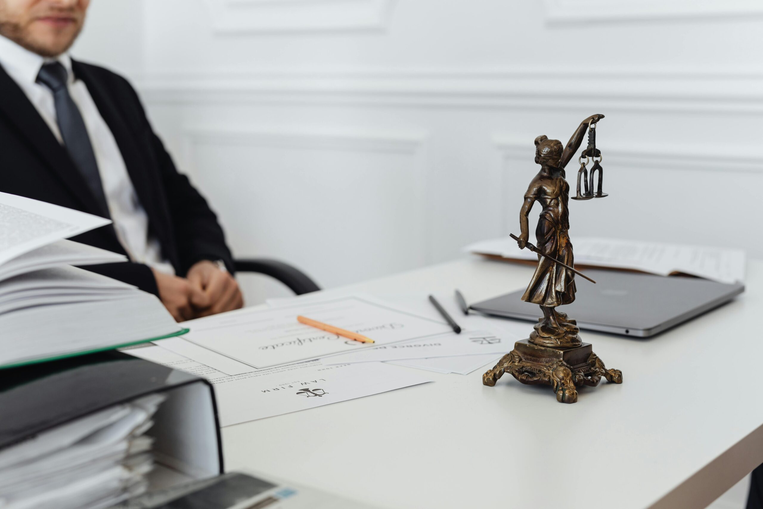 Man sitting at a table with documents and the scales of justice