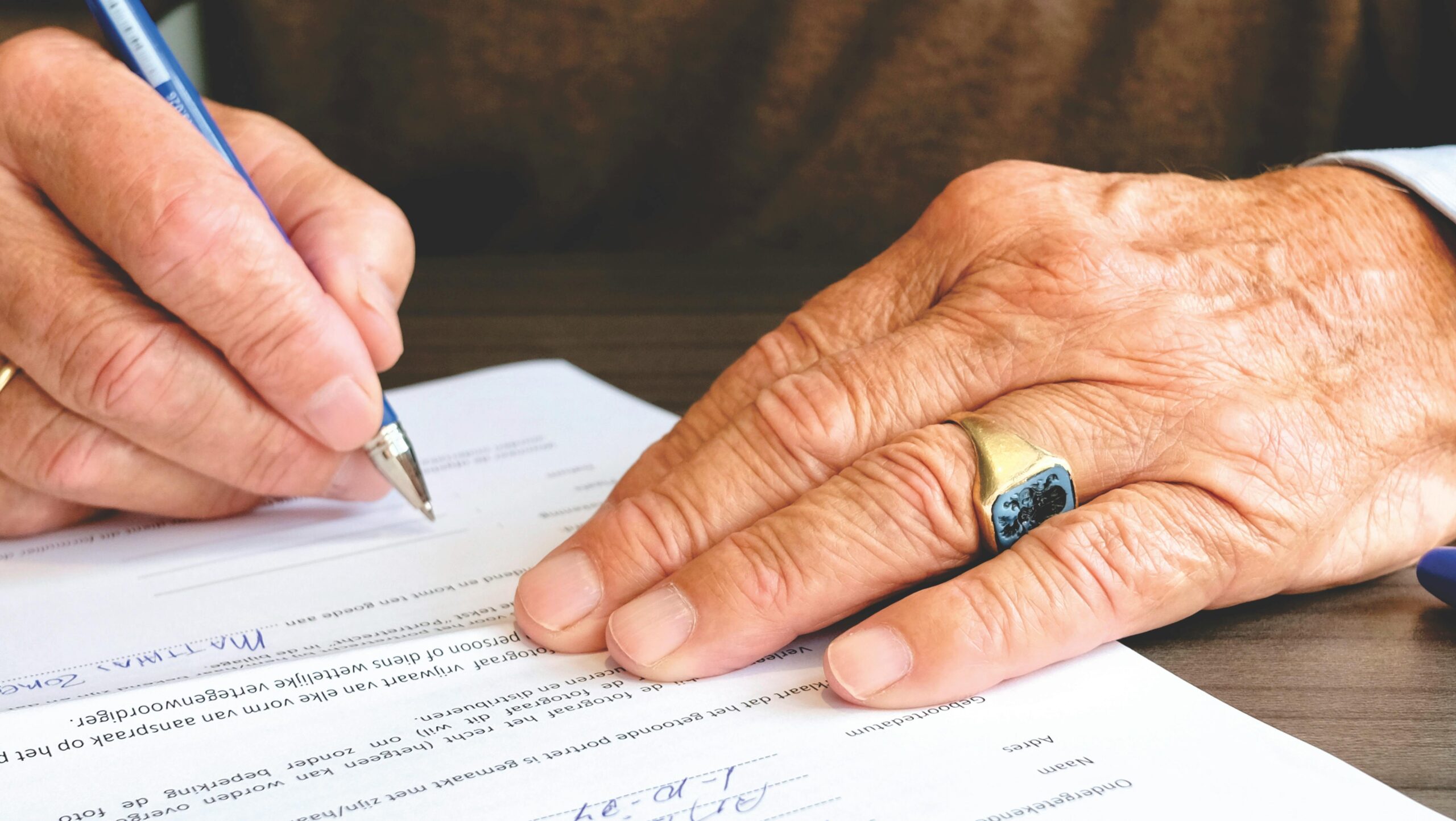 Man writing with a pen on a document