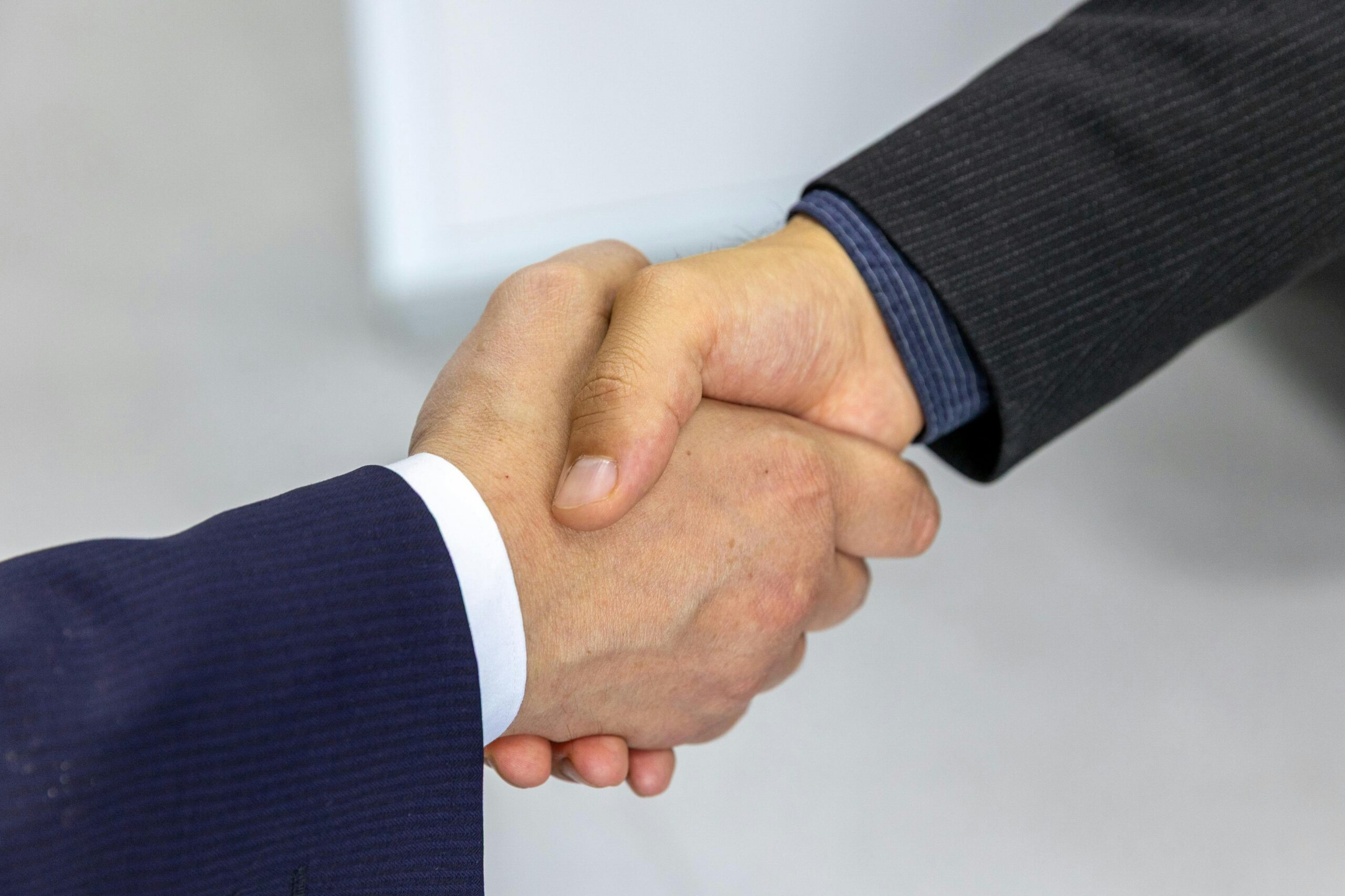 Two men in suits shaking hands