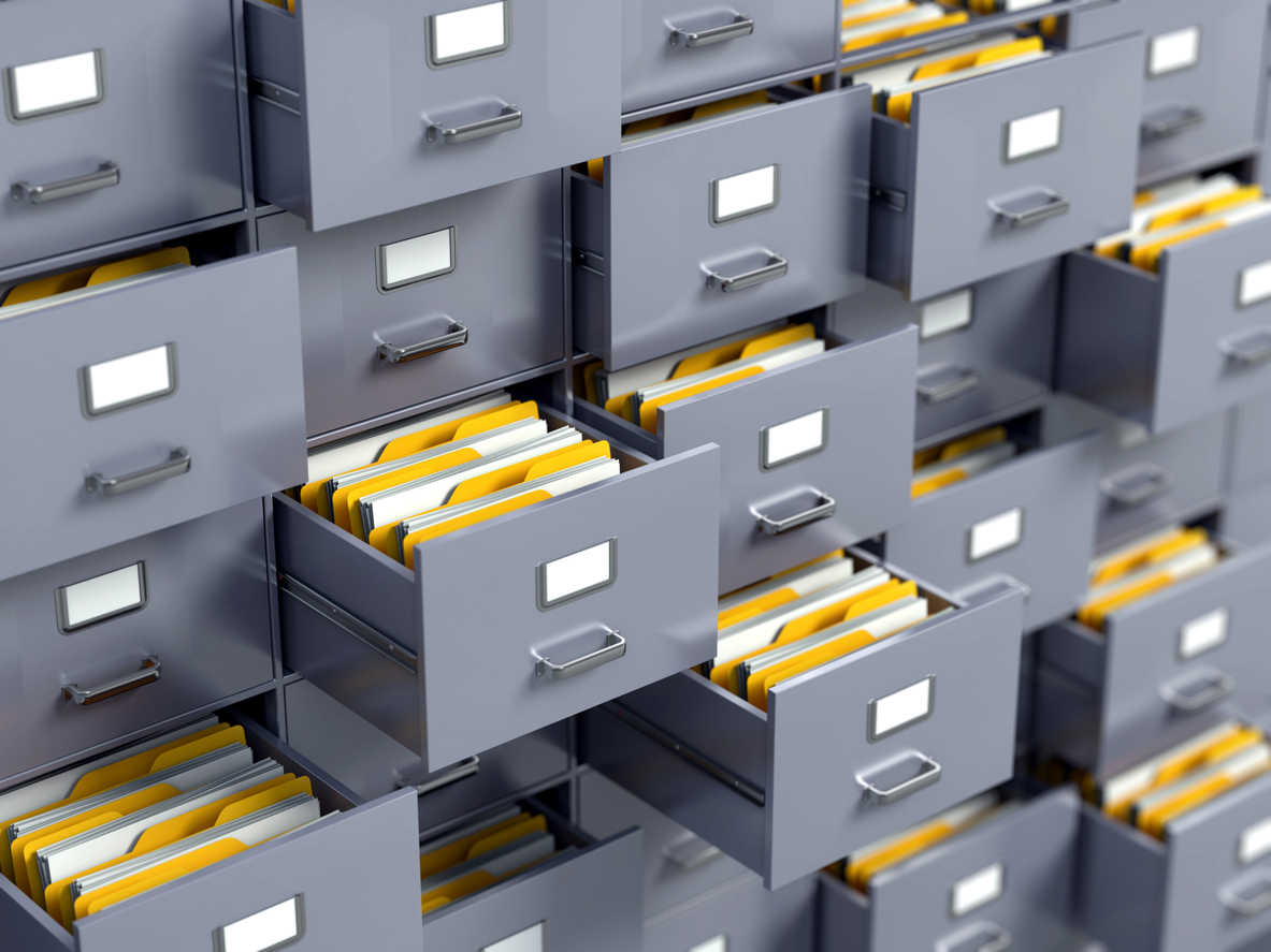 Rows of filing cabinets open with folders inside